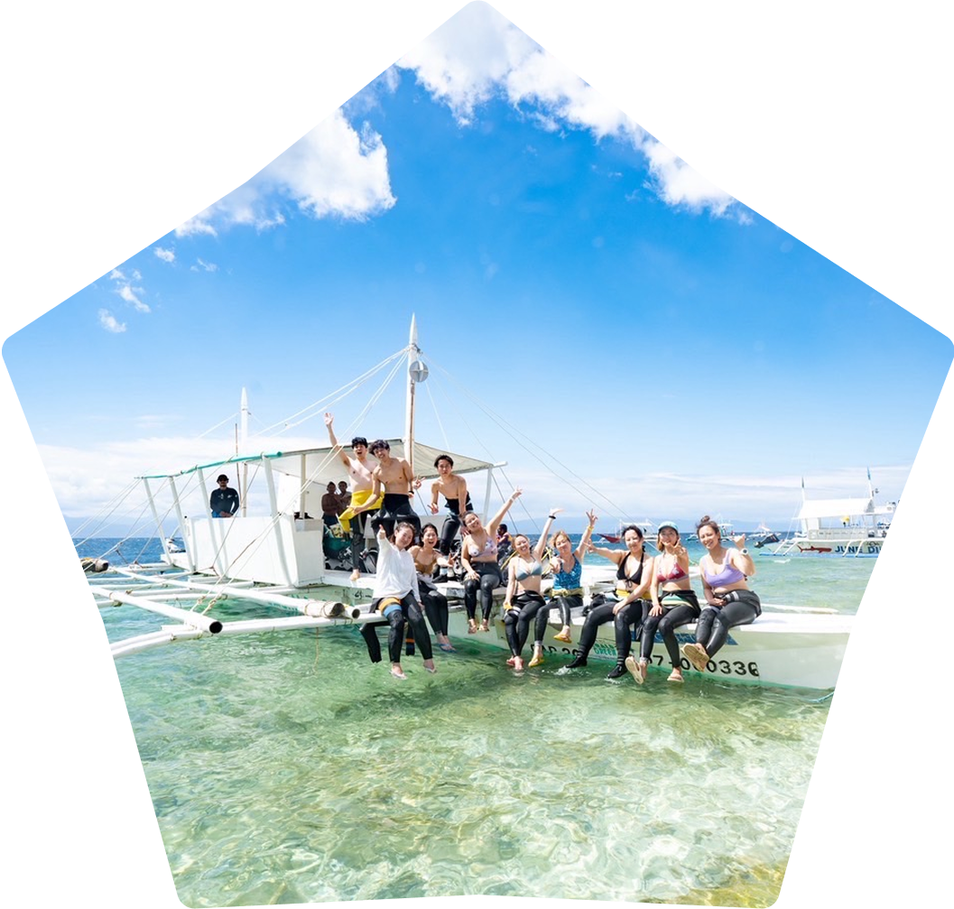 男女のダイバーが船の上で立って笑っている